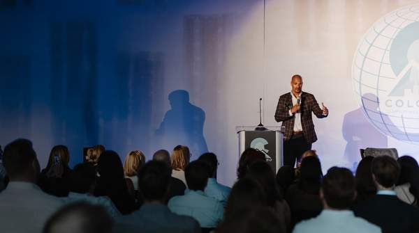 Futuristic Denver cityscape with AI network lines, founders collaborating around a holographic display, symbolizing innovation and community at Colorado Startup Week.